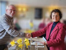 Barbara Kirk receiving her membership certificate and lapel pin from President Nigel Clark.